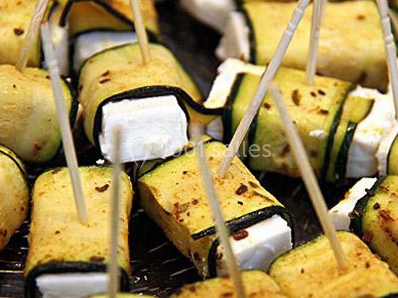 Roulés de courgettes grillées farcis de fromage blanc, maintenus par des pics en bois.