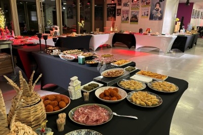 Buffet avec des plateaux d'huîtres, verrines et autres mets disposés sur une longue table dans une salle lumineuse.