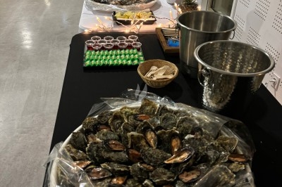 Buffet avec des plateaux d'huîtres, verrines et autres mets disposés sur une longue table dans une salle lumineuse.