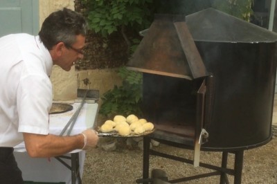 Chambre mansardée avec deux lits simples, parquet clair, poutres apparentes et lumière naturelle provenant d'un velux.