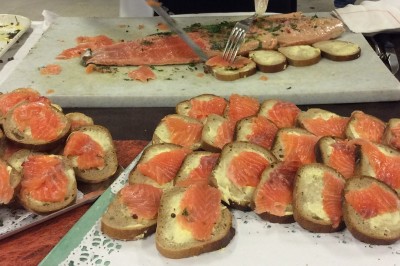Chambre mansardée avec deux lits simples, parquet clair, poutres apparentes et lumière naturelle provenant d'un velux.