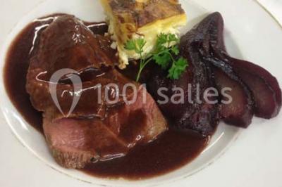 Chambre mansardée avec deux lits simples, parquet clair, poutres apparentes et lumière naturelle provenant d'un velux.