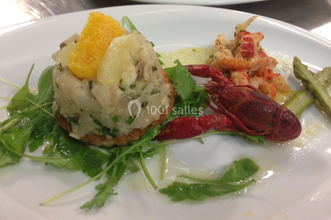 Assiette gastronomique composée de chair de poisson, écrevisse, asperges, roquette et segments d'orange.