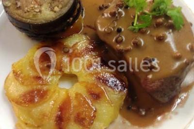 Chambre mansardée avec deux lits simples, parquet clair, poutres apparentes et lumière naturelle provenant d'un velux.