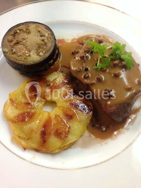 Assiette composée de viande en sauce, gratin de pommes de terre et rondelles d’aubergine grillées.