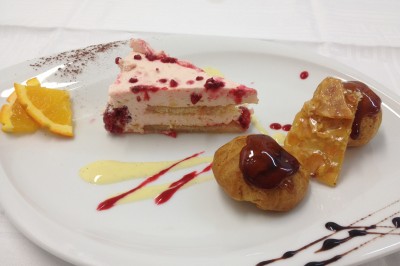 Chambre mansardée avec deux lits simples, parquet clair, poutres apparentes et lumière naturelle provenant d'un velux.