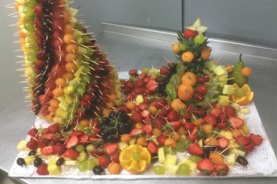 Chambre mansardée avec deux lits simples, parquet clair, poutres apparentes et lumière naturelle provenant d'un velux.