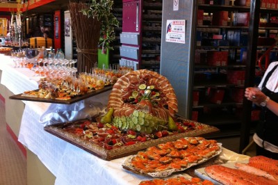 Chambre mansardée avec deux lits simples, parquet clair, poutres apparentes et lumière naturelle provenant d'un velux.
