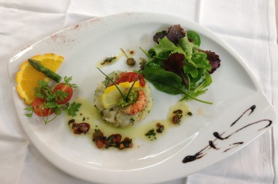 Chambre mansardée avec deux lits simples, parquet clair, poutres apparentes et lumière naturelle provenant d'un velux.