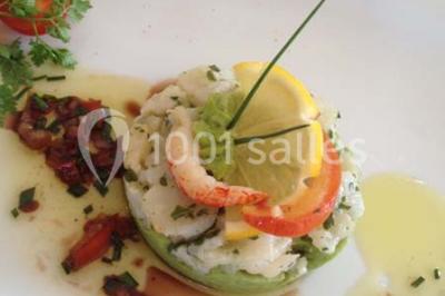 Chambre mansardée avec deux lits simples, parquet clair, poutres apparentes et lumière naturelle provenant d'un velux.