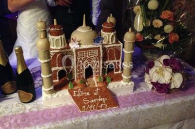 Salle avec des rangées de chaises en plastique blanc disposées face à une scène lumineuse dans un espace aux murs clairs.