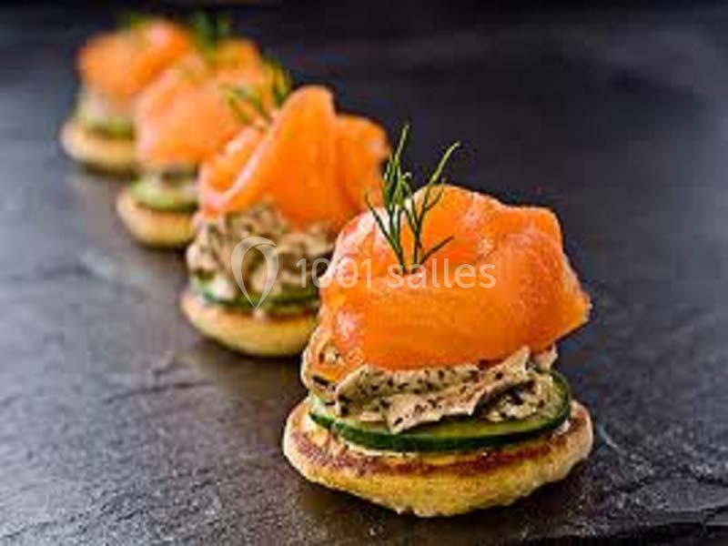 Blinis garnis de tranches de saumon fumé, crème aux herbes, rondelles de concombre et brins d'aneth.