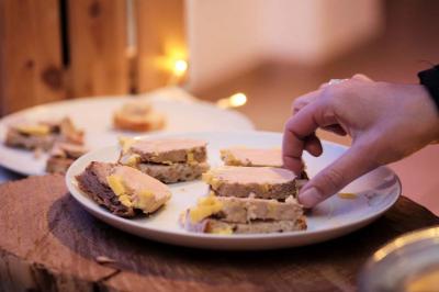 Un kiosque blanc au bord d'un étang avec une fontaine, entouré d'arbres et d'une réception en arrière-plan.
