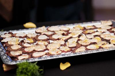 Un kiosque blanc au bord d'un étang avec une fontaine, entouré d'arbres et d'une réception en arrière-plan.