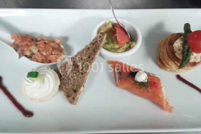 Plateau de canapés variés avec des garnitures salées, disposés de manière symétrique sur une surface métallique.