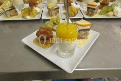 Plateau de canapés variés avec des garnitures salées, disposés de manière symétrique sur une surface métallique.