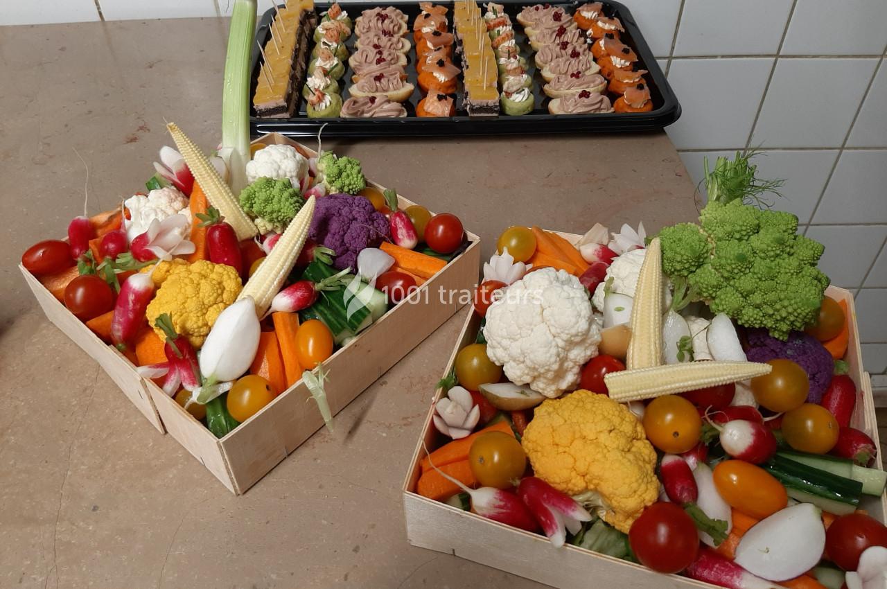 Plateaux de légumes colorés avec choux, tomates cerises, radis et mini-épis de maïs, accompagnés d'amuse-bouches en arrière…