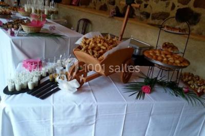 Tour de choux décorée avec des fleurs et des étincelles, entourée de desserts sur une table de réception.
