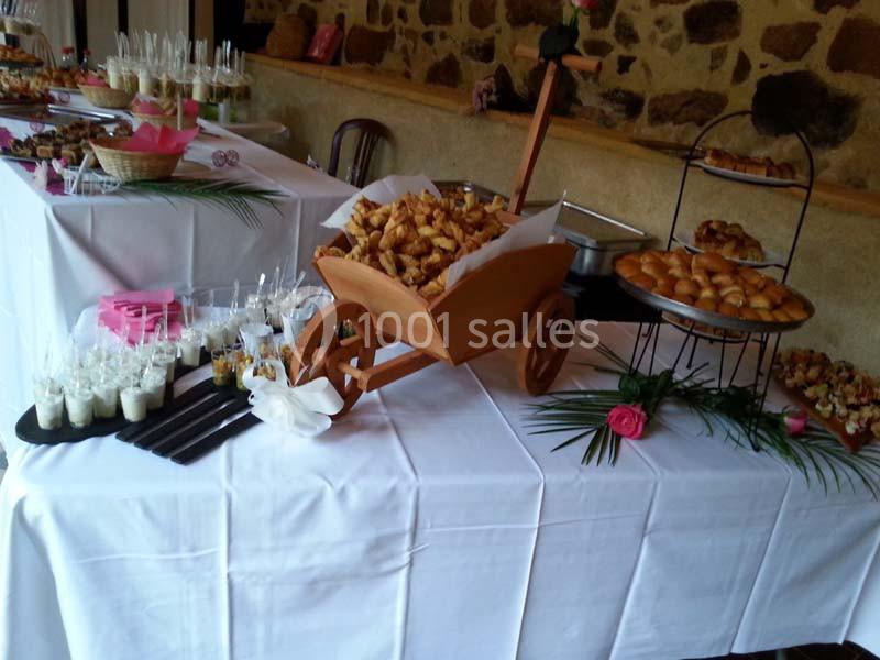 Buffet de réception avec viennoiseries, verrines et autres mets disposés sur des nappes blanches.