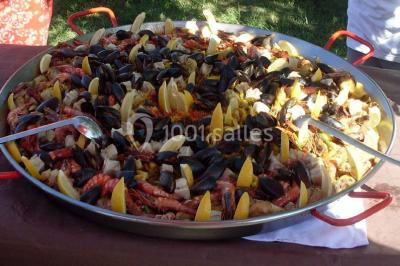 Tour de choux décorée avec des fleurs et des étincelles, entourée de desserts sur une table de réception.