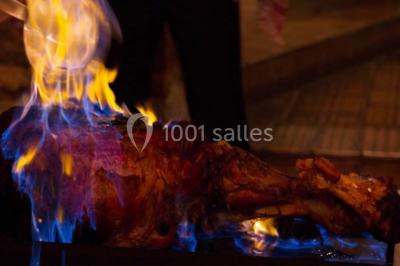Tour de choux décorée avec des fleurs et des étincelles, entourée de desserts sur une table de réception.