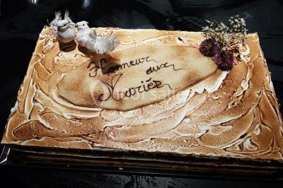 Tour de choux décorée avec des fleurs et des étincelles, entourée de desserts sur une table de réception.
