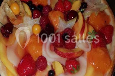 Tour de choux décorée avec des fleurs et des étincelles, entourée de desserts sur une table de réception.