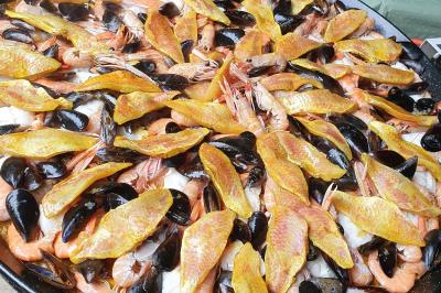 Tour de choux décorée avec des fleurs et des étincelles, entourée de desserts sur une table de réception.