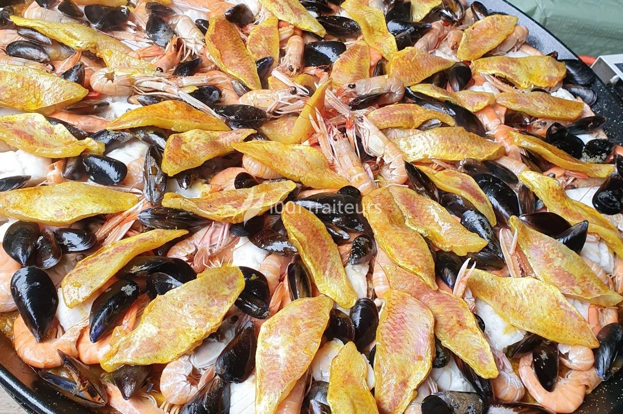 Plat de paella garni de crevettes, moules, filets de rouget et riz safrané.