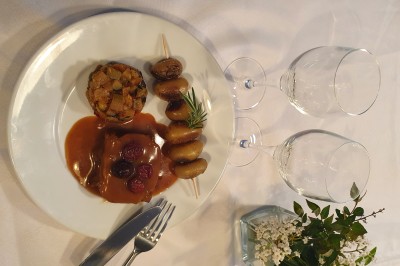 Un camion de traiteur avec des illustrations culinaires, accompagné de personnes préparant et servant des plats.