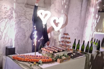 Un camion de traiteur avec des illustrations culinaires, accompagné de personnes préparant et servant des plats.