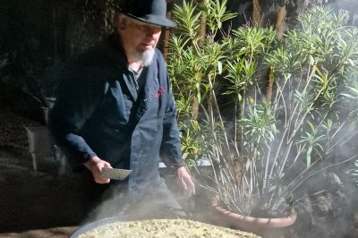 Un camion de traiteur avec des illustrations culinaires, accompagné de personnes préparant et servant des plats.
