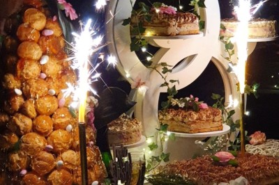 Un camion de traiteur avec des illustrations culinaires, accompagné de personnes préparant et servant des plats.