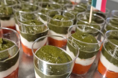 Un camion de traiteur avec des illustrations culinaires, accompagné de personnes préparant et servant des plats.