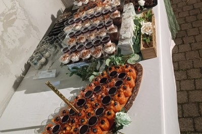 Un camion de traiteur avec des illustrations culinaires, accompagné de personnes préparant et servant des plats.