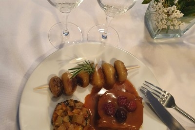 Un camion de traiteur avec des illustrations culinaires, accompagné de personnes préparant et servant des plats.