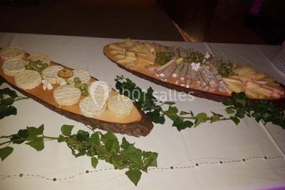 Tour de choux décorée avec des fleurs et des étincelles, entourée de desserts sur une table de réception.