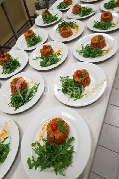 Assiettes de taboulé garni de roquette et de tomates cerises, alignées sur une table blanche.