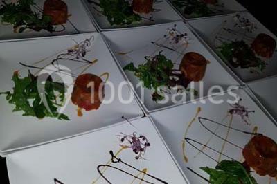 Tour de choux décorée avec des fleurs et des étincelles, entourée de desserts sur une table de réception.