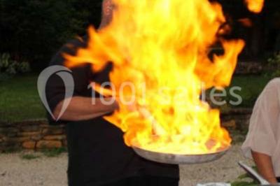 Tour de choux décorée avec des fleurs et des étincelles, entourée de desserts sur une table de réception.