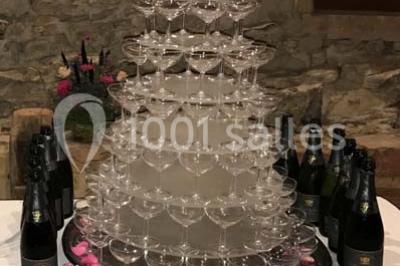 Tour de choux décorée avec des fleurs et des étincelles, entourée de desserts sur une table de réception.