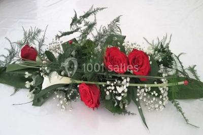 Tour de choux décorée avec des fleurs et des étincelles, entourée de desserts sur une table de réception.