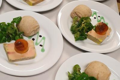 Tour de choux décorée avec des fleurs et des étincelles, entourée de desserts sur une table de réception.