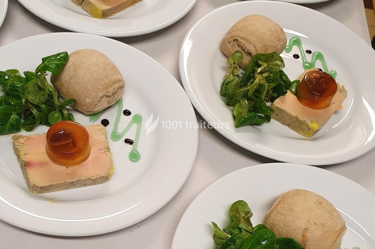 Assiette composée de foie gras, gelée, salade verte, sauce décorative et petit pain.