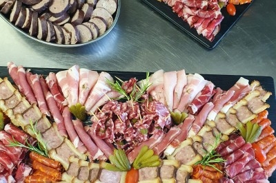 Buffet d'anniversaire en extérieur avec nappes blanches, plats variés, boissons et décor champêtre.