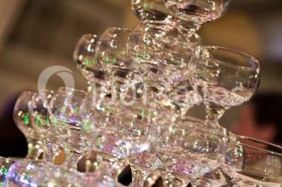 Fontaine à chocolat sur une table de buffet avec des fruits frais et des brochettes en arrière-plan.