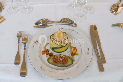 Fontaine à chocolat sur une table de buffet avec des fruits frais et des brochettes en arrière-plan.