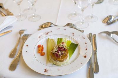 Fontaine à chocolat sur une table de buffet avec des fruits frais et des brochettes en arrière-plan.