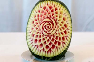 Fontaine à chocolat sur une table de buffet avec des fruits frais et des brochettes en arrière-plan.