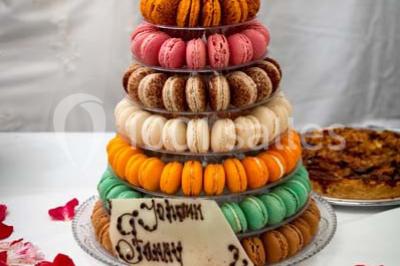 Fontaine à chocolat sur une table de buffet avec des fruits frais et des brochettes en arrière-plan.